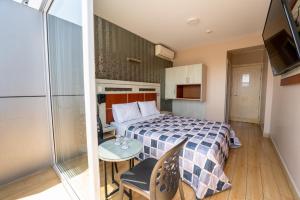 um quarto com uma cama, uma mesa e uma televisão em Quadrum em Lima