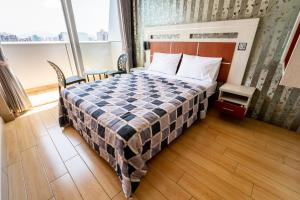 um quarto com uma cama com um cobertor xadrez em Quadrum em Lima