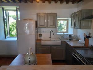 Una cocina con un refrigerador blanco y un fregadero. en Maison DU VERGER, en Quarré-les-Tombes
