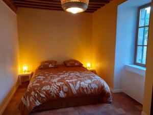 Un dormitorio con una cama con dos lámparas sobre dos mesas. en Maison DU VERGER, en Quarré-les-Tombes