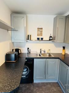 a kitchen with a sink and a washing machine at Fly Hi-Town Centre Apartment in Ifield +23 photos