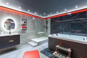 ein Badezimmer mit Badewanne, Waschbecken und Spiegel in der Unterkunft Secret Night Pamiers in Pamiers + 5 Fotos