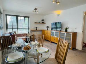 a dining room with a glass table and chairs at Fly Hi-Town Centre Apartment in Ifield