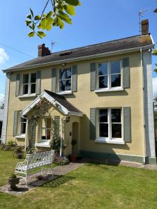 una casa con una panchina davanti di Giltar Grove Country House a Tenby