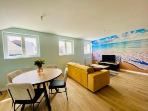 un salon avec un canapé jaune et une table dans l'établissement Les gîtes du pécheur !, au Crotoy