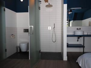 a bathroom with a shower with a toilet and a sink at Station 14 in Ouddorp