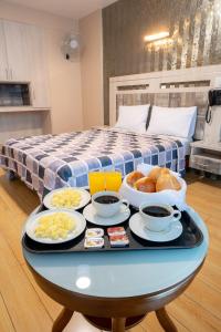 uma bandeja de comida numa mesa em frente a uma cama em Quadrum em Lima