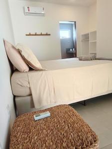 een slaapkamer met twee bedden en een afstandsbediening op een voetenbankje bij Casa Duna - Family Friendly in São Miguel do Gostoso