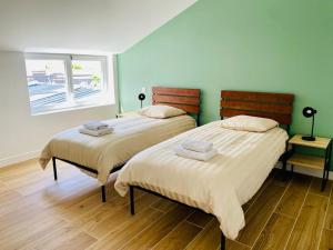 deux lits côte à côte dans une pièce dans l'établissement Les gîtes du pécheur !, au Crotoy