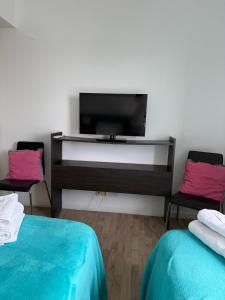 een kamer met 2 bedden en een flatscreen-tv bij Apart Metropolitan in Buenos Aires