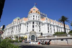 a large white building with a flag on top of it at Seytour Central Place in Nice