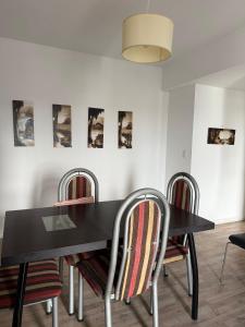 een eetkamer met een zwarte tafel en stoelen bij Apart Metropolitan in Buenos Aires