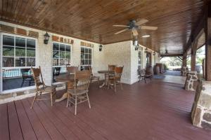 a porch with a ceiling fan and tables and chairs at Best Western Plus Fredericksburg in Fredericksburg