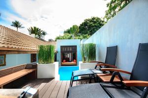 a patio with chairs and tables and a blue wall at Pao Jin Poon Villa in Lamai