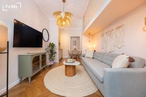 een woonkamer met een blauwe bank en een tv bij FABEL Apartments am Zoo in Berlijn