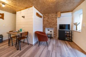 Una habitación con una mesa y sillas y un televisor. en Les cols, en Sainte-Marie-de-Cuines
