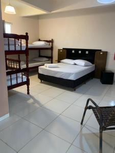 una camera con 2 letti a castello e una sedia di Pousada Rota do Parque a Penha