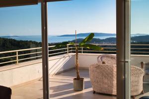 a balcony with two chairs and a palm tree on it at Villa Campagna in Trogir