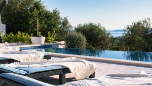 a pool with two lounge chairs and a swimming pool at Villa Campagna in Trogir