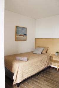 una cama en una habitación con un cuadro en la pared en Hábitat, en Estación Pamplona