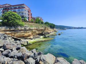 a view of a river with rocks and a building at Golden Lady in Sveti Vlas