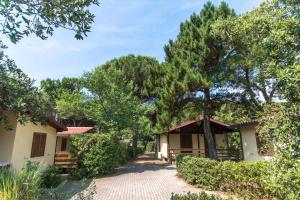 a house with trees and a brick driveway at Village Camping Hawaii in Albinia