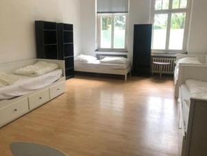 a room with two beds and a wooden floor at Villa Solingen - flexible & sehr günstige möblierte Zimmer auf Zeit möglich in Solingen