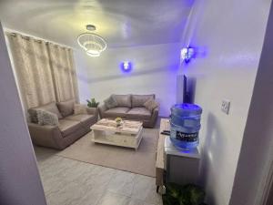 ein Wohnzimmer mit Sofa und Tisch in der Unterkunft Cozy homes in ruiru, OJ in Gatunga