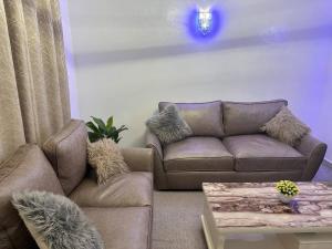 ein Wohnzimmer mit Sofa und Tisch in der Unterkunft Cozy homes in ruiru, OJ in Gatunga + 2 Fotos