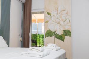 una camera da letto con un dipinto a fiori sul muro di Solis Giselle Hotel a Vlorë