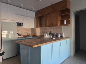 a kitchen with blue cabinets and a wooden counter top at Luxury Chalet Il Monte Galala in Ain Sokhna