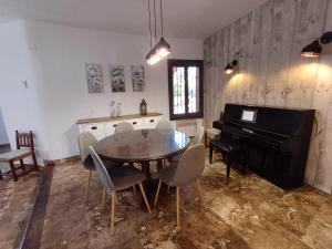a dining room with a table and a piano at La Font Moraira in Moraira