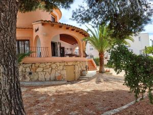 a house with a palm tree in front of it at La Font Moraira in Moraira