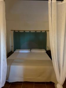 a bedroom with a bed with curtains around it at Dammuso del Nonno in Pantelleria