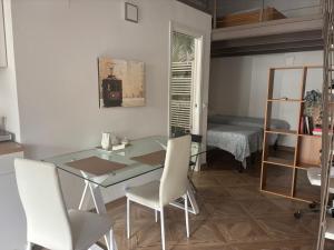 a dining room with a glass table and white chairs at LOVELYLOFT, via Meda in Milan