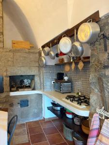 a kitchen with a stove and some pots and pans at Dammuso del Nonno in Pantelleria