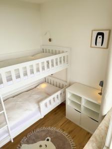a white bedroom with a bunk bed and a desk at Apartment Rehberg 14 OG Panorama Balkon Pool Sauna in Braunlage +28 photos