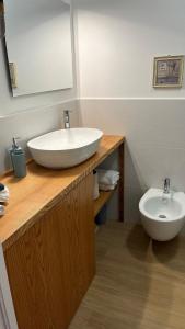 a bathroom with a white sink and a toilet at Enhorabona Beach House in Alghero