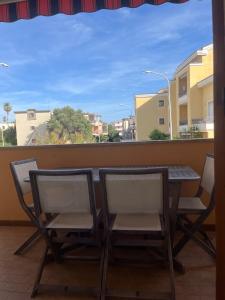 a table and chairs on a balcony with a view at Enhorabona Beach House in Alghero +11 photos