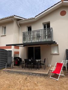 a patio with a table and chairs in front of a house at Villa de 6 pers, 500m plage. in Soulac-sur-Mer