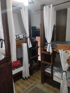 a room with three bunk beds and a desk at Cabana Hostel Guarulhos - SELF CHECK IN in Guarulhos