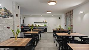 a dining room with wooden tables and chairs at Willa Jaśmin Domki, Apartamenty, Pokoje nad morzem in Mielenko