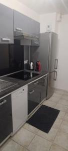 a kitchen with a black and white kitchen at LOCATION SAISONNIERE VILLEJUIF à 15 MIN en voiture DE PARIS in Villejuif +8 photos