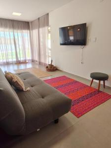 een woonkamer met een bank en een televisie bij Casa Duna - Family Friendly in São Miguel do Gostoso +52 foto's