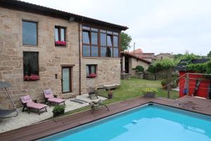 a house with a swimming pool in the yard at Aturuxo, Casa dos Mestres in Trasmiras