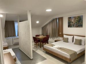 a bedroom with a bed and a table and chairs at Astoria Struga in Struga