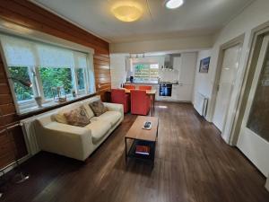 a living room with a couch and a table at Cottage in Veluwe near Forest Park in Garderen