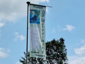 a banner on a pole in front of a tree at Cottage in Veluwe near Forest Park in Garderen