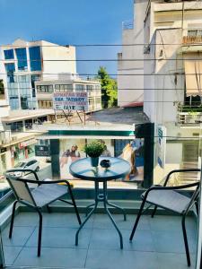 - un balcon avec une table et deux chaises dans l'établissement Ionia's Comfort Appartments -2nd floor, à Athènes