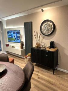 un soggiorno con orologio a muro e tavolo di Getaway to Le Touquet - évasion au touquet a Le Touquet-Paris-Plage